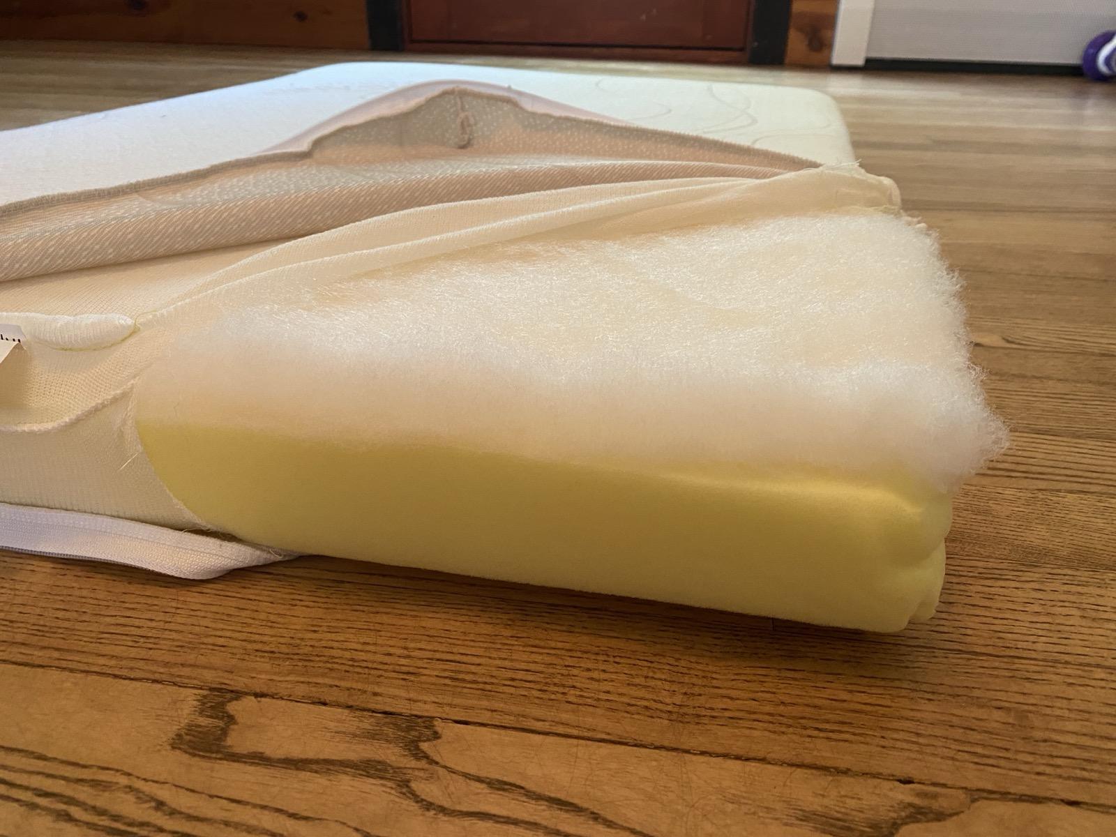 Stock RV mattress torn open showing low-density foam